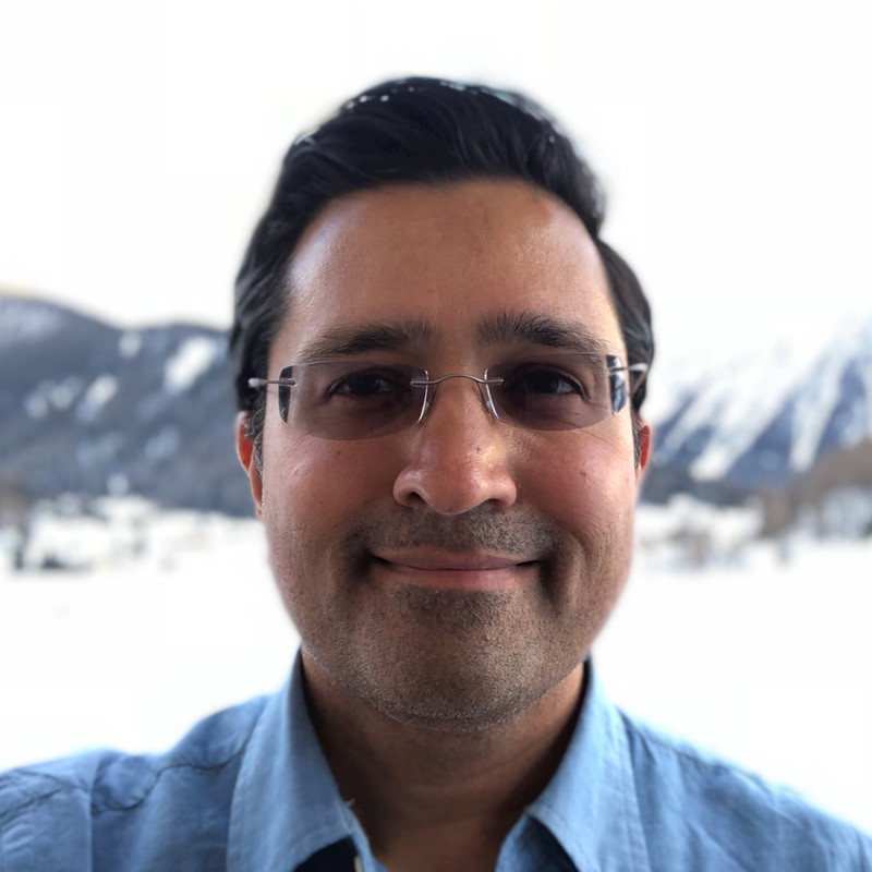 A person wearing glasses and smiling at the camera

Description automatically generated