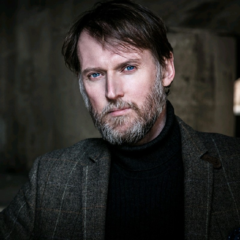 A person wearing a suit and tie

Description automatically generated