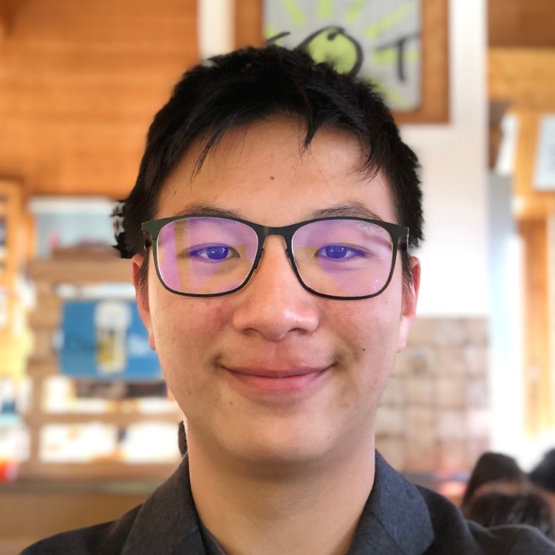 A person wearing glasses and smiling at the camera

Description automatically generated