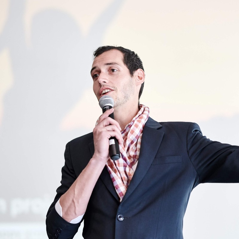 A person wearing a suit and tie talking on a cell phone

Description automatically generated